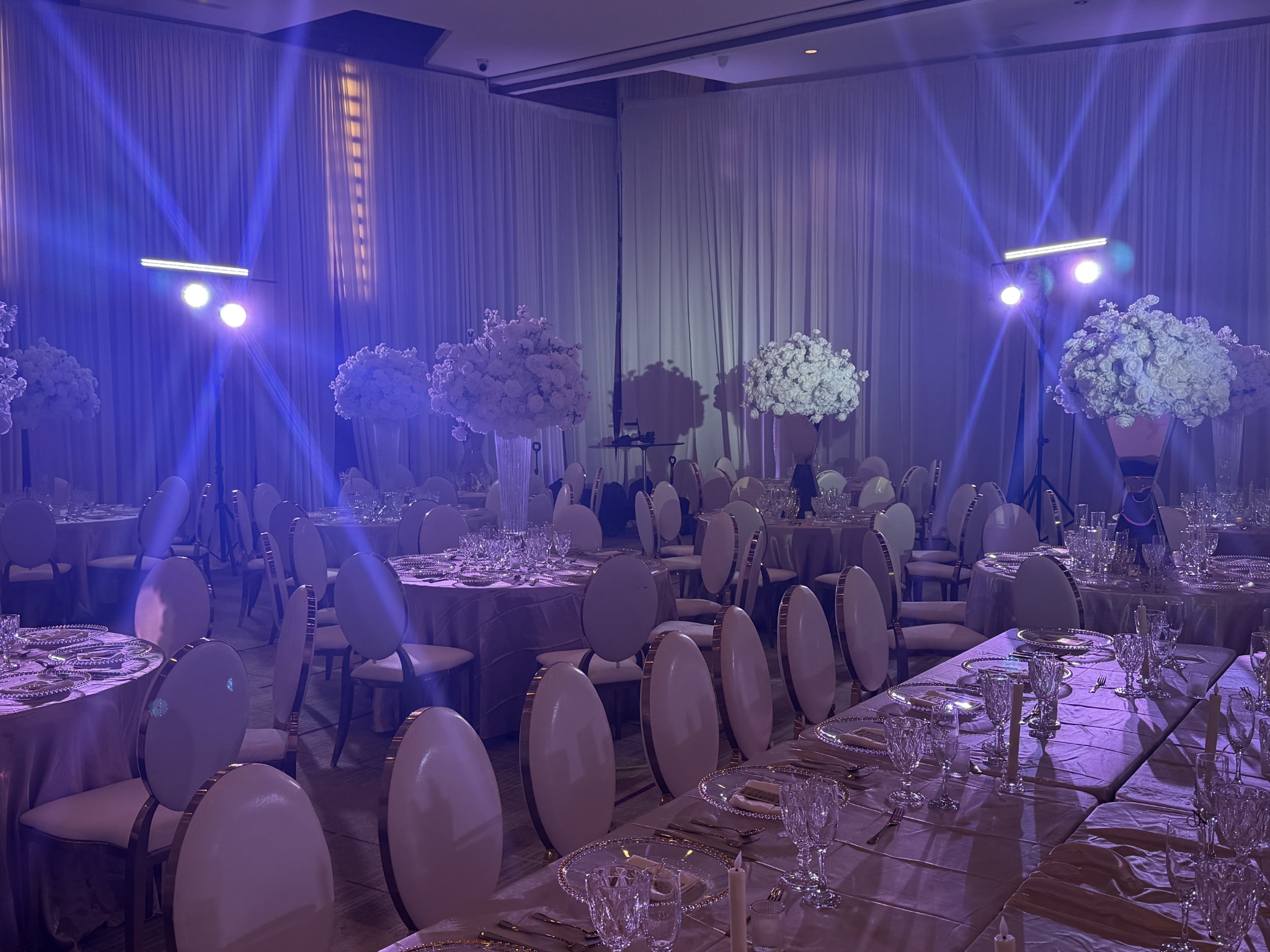 Light rays above white floral centerpieces and formal table settings